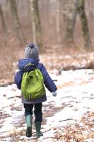 A child in a jacket and beany walks in the snow